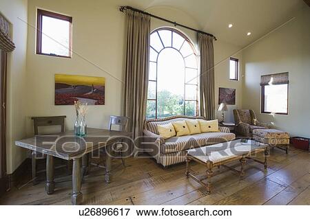 Stock Photo - Arched window and sofa in living room with high ceiling. Fotosearch