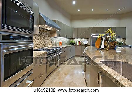 Stock Image - Architecturally designed kitchen with stainless steel fitted units. Fotosearch