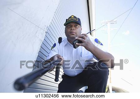 Armed security guard investigates with walk talky View Large Photo Image Stock Photograph - Armed security guard investigates with walk talky. Fotosearch