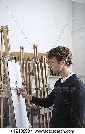 Artist drawing charcoal portrait in studio, side view View Large Photo Image Stock Photo - Artist drawing charcoal portrait in studio, side view. Fotosearch