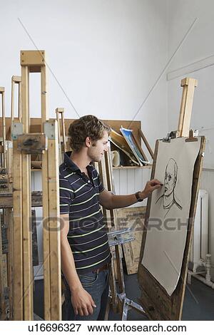 Stock Photo - Artist drawing charcoal portrait in studio, side view. Fotosearch