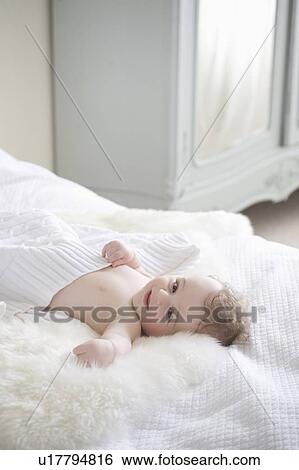 Baby boy lying on fur blanket View Large Photo Image Stock Photograph - Baby boy lying on fur blanket. Fotosearch