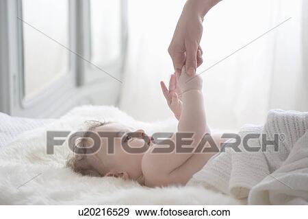 Baby boy reaches for mother's hand View Large Photo Image Stock Photo - Baby boy reaches for mother's hand. Fotosearch