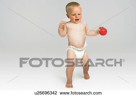 Stock Image - Baby Holding Red Ball. Fotosearch