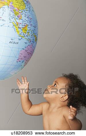 Stock Image - Baby Looking at Globe. Fotosearch