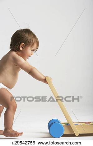 Baby Pushing Toy Cart View Large Photo Image Stock Photograph - Baby Pushing Toy Cart. Fotosearch