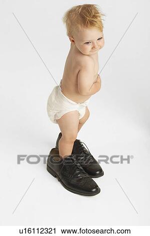 Baby Standing in Man's Shoes View Large Photo Image Stock Image - Baby Standing in Man's Shoes. Fotosearch