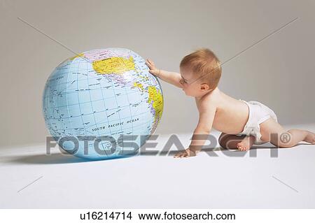 Picture - Baby touching inflatable globe. Fotosearch