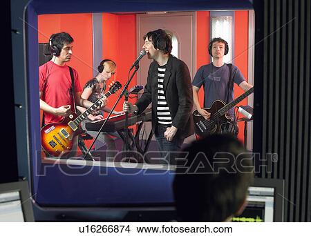 Picture - Band in recording studio, technician in foreground. Fotosearch