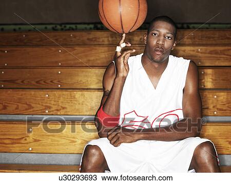 Stock Image - Basketball player ball spinning ball on finger, portrait. Fotosearch