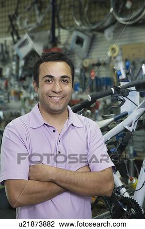 Bike shop assistant stands with arms folded View Large Photo Image Stock Image - Bike shop assistant stands with arms folded. Fotosearch