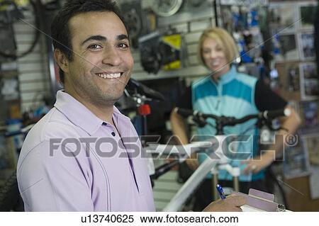 Bike shop assistant with female cyclist View Large Photo Image Stock Photography - Bike shop assistant with female cyclist. Fotosearch