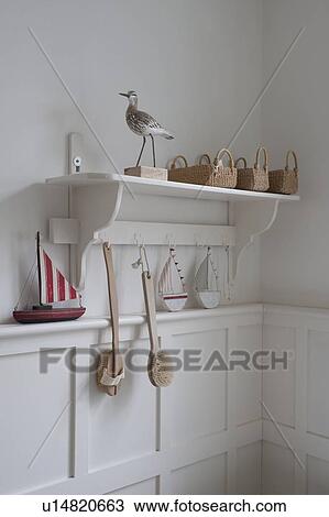 Stock Image - Bird statue and baskets on bathroom shelf, London. Fotosearch