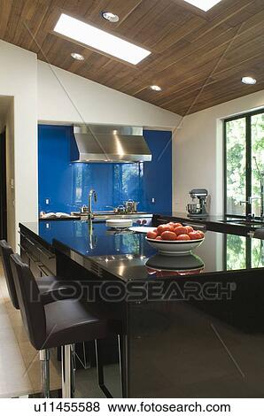 Stock Photo - Blue splashback in black gloss kitchen. Fotosearch