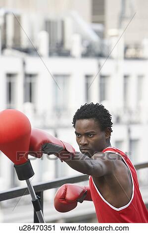 Boxer punching punch ball on downtown balcony View Large Photo Image Stock Image - Boxer punching punch ball on downtown balcony. Fotosearch
