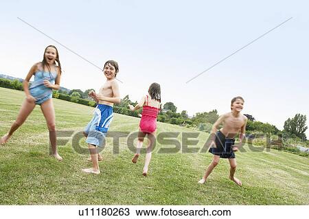 Boys and Girls in Swimsuits playing in field View Large Photo Image Stock Image - Boys and Girls in Swimsuits playing in field. Fotosearch