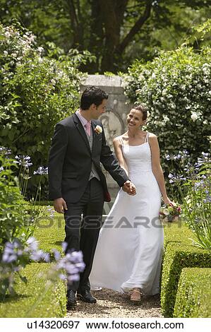 Bride and groom walking in garden, back view View Large Photo Image Stock Photo - Bride and groom walking in garden, back view. Fotosearch