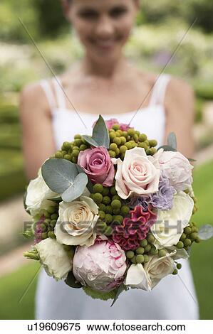 Stock Photography - Bride holding bouquet, close-up, focus on foreground. Fotosearch