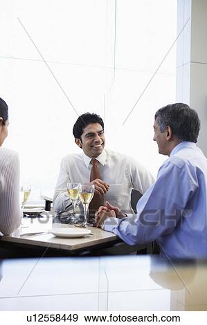 Stock Photo - Business associates smiling having business meeting. Fotosearch
