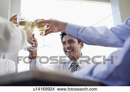 Picture - Business associates toasting with wine glasses, close-up. Fotosearch
