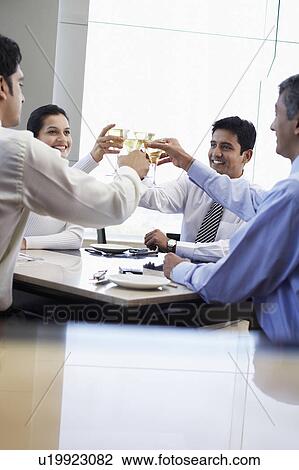 Stock Image - Business associates toasting with wine glasses. Fotosearch