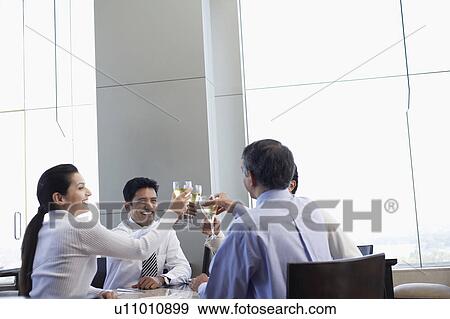 Stock Photo - Business associates toasting with wine glasses. Fotosearch