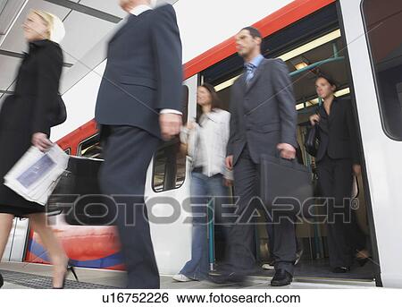 Stock Photograph - Business Commuters Getting off a Train, motion blur, low angle view. Fotosearch
