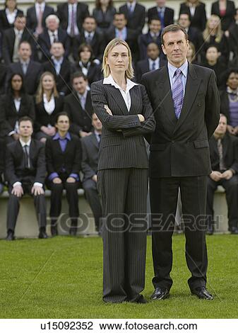 Business couple standing in front of business people sitting in bleachers, portrait View Large Photo Image Stock Image - Business couple standing in front of business people sitting in bleachers, portrait. Fotosearch