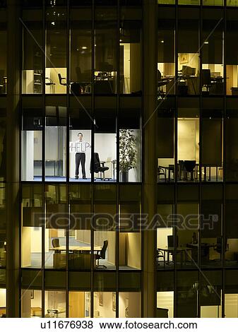 Business man holding help sign in office, view from building exterior View Large Photo Image Stock Photo - Business man holding help sign in office, view from building exterior. Fotosearch
