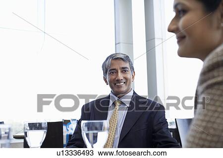 Business man looking at colleague, smiling View Large Photo Image Stock Image - Business man looking at colleague, smiling. Fotosearch