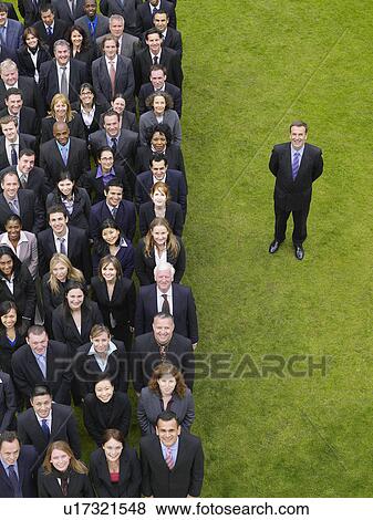 Stock Photo - Business man standing next to large group of business people in formation, elevated view, portrait. Fotosearch