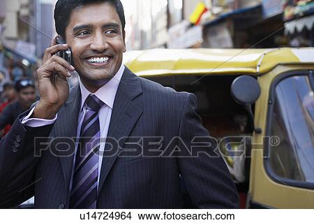 Business man using cell phone, smiling View Large Photo Image Picture - Business man using cell phone, smiling. Fotosearch