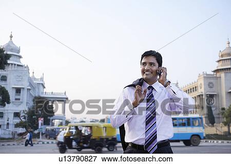 Business man using cell phone, smiling View Large Photo Image Stock Photo - Business man using cell phone, smiling. Fotosearch