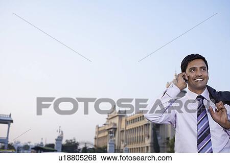 Business man using cell phone, smiling View Large Photo Image Stock Photo - Business man using cell phone, smiling. Fotosearch