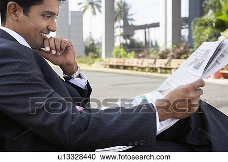 Stock Image - Business man using mobile phone on city street. Fotosearch