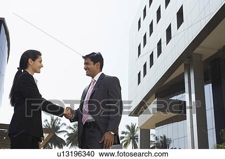 Stock Image - Business people smiling in city. Fotosearch