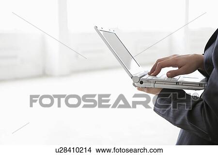 Business woman holds laptop in empty warehouse View Large Photo Image Picture - Business woman holds laptop in empty warehouse. Fotosearch