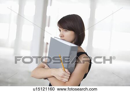 Business woman on holding file in warehouse interior View Large Photo Image Stock Image - Business woman on holding file in warehouse interior. Fotosearch