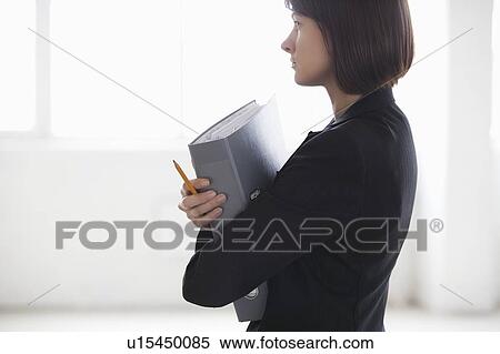 Business woman on holding file in warehouse interior View Large Photo Image Stock Photography - Business woman on holding file in warehouse interior. Fotosearch