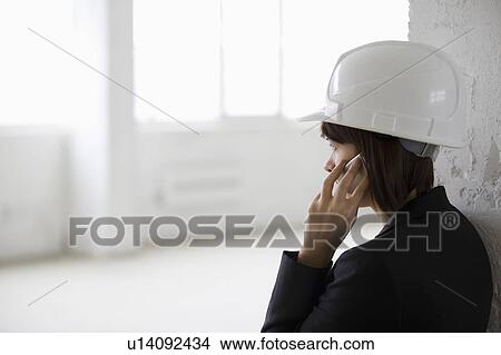 Business woman on mobile phone in empty warehouse View Large Photo Image Picture - Business woman on mobile phone in empty warehouse. Fotosearch