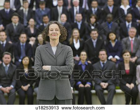 Business woman standing in front of business people sitting in bleachers, portrait View Large Photo Image Stock Image - Business woman standing in front of business people sitting in bleachers, portrait. Fotosearch
