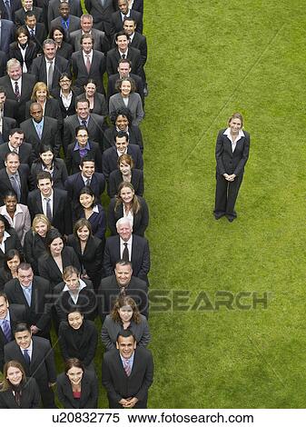 Business woman standing next to large group of business people in formation, elevated view, portrait View Large Photo Image Stock Photography - Business woman standing next to large group of business people in formation, elevated view, portrait. Fotosearch
