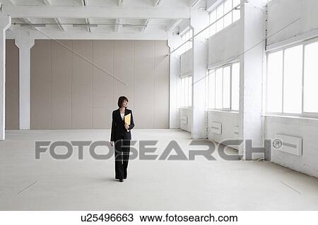 Business woman stands in empty warehouse View Large Photo Image Stock Image - Business woman stands in empty warehouse. Fotosearch