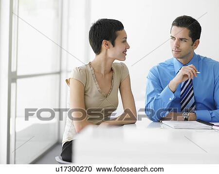 Businessman and businesswoman at office table in discussion View Large Photo Image Stock Image - Businessman and businesswoman at office table in discussion. Fotosearch