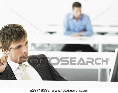 Businessman at desk contemplating in front of computer View Large Photo Image Stock Image - Businessman at desk contemplating in front of computer. Fotosearch