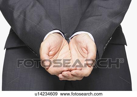 Stock Photo - Businessman Cupping His Hands, close-up on hands, mid section. Fotosearch