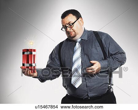 Picture - Businessman holding sticks of dynamite. Fotosearch