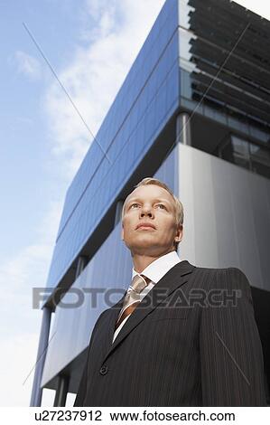 Stock Image - Businessman, portrait, low angle view. Fotosearch