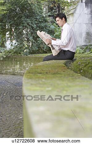 Stock Photo - Businessman Reading Newspaper Outdoors. Fotosearch