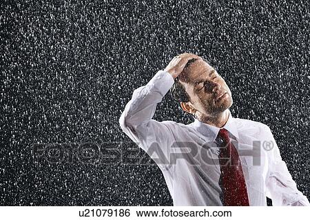 Businessman running hands through wet hair, standing in the Rain View Large Photo Image Stock Photograph - Businessman running hands through wet hair, standing in the Rain. Fotosearch